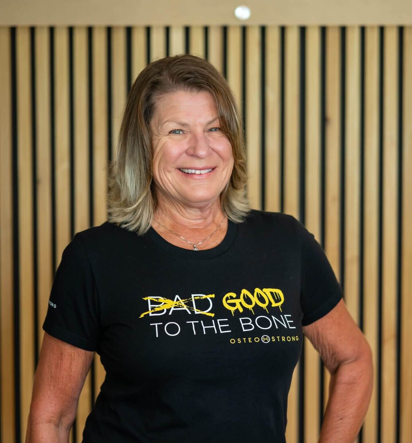Smiling woman wearing "Good to the Bone" shirt.