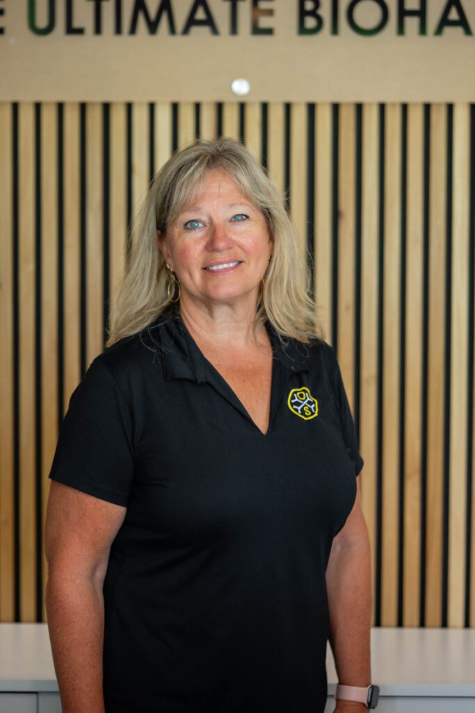 Smiling woman in black shirt indoors.