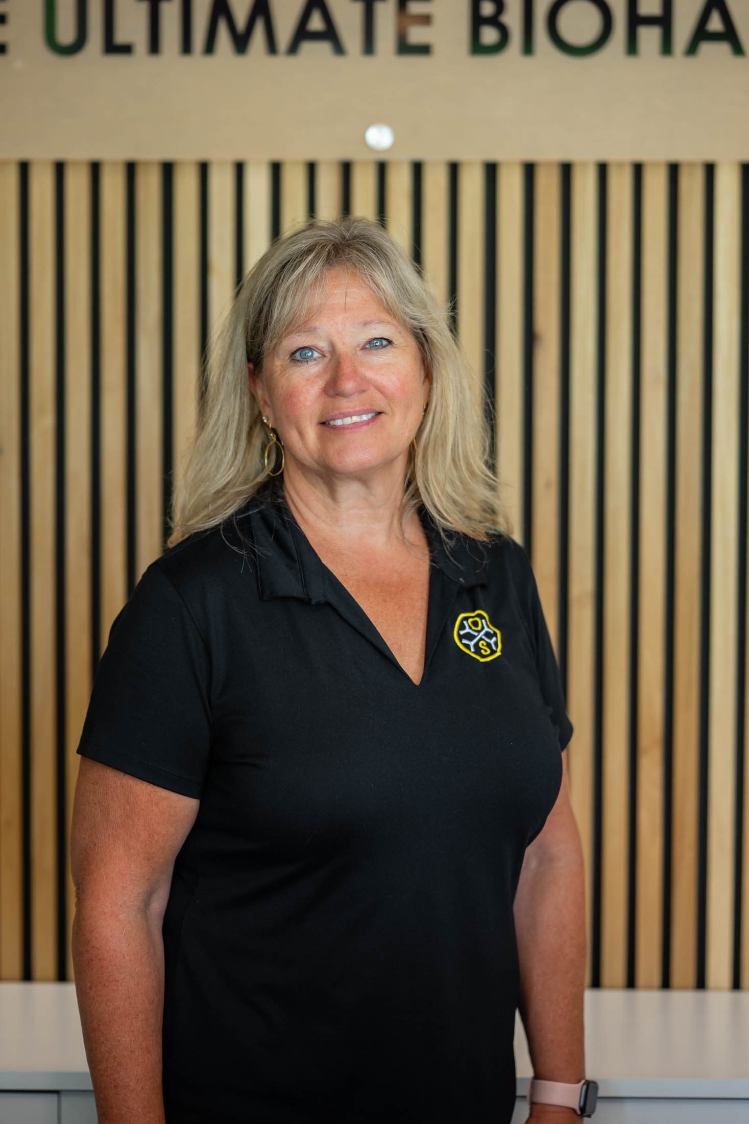 Smiling woman in black shirt indoors.