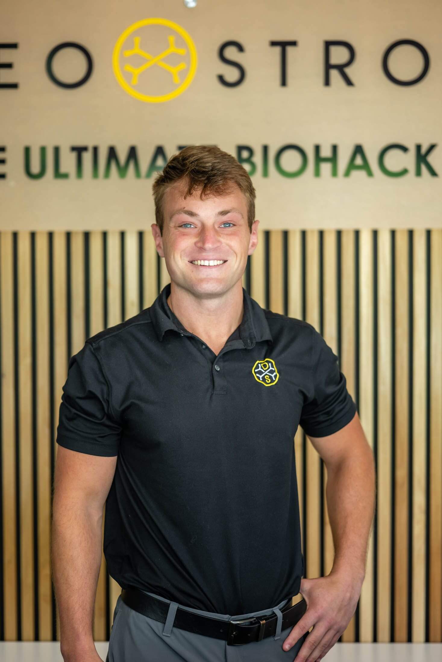 Smiling man in branded polo shirt.