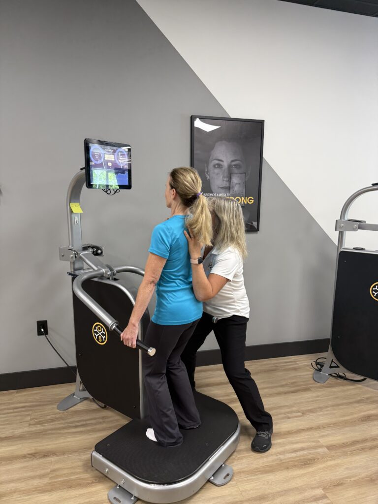 Two women using exercise equipment in gym.