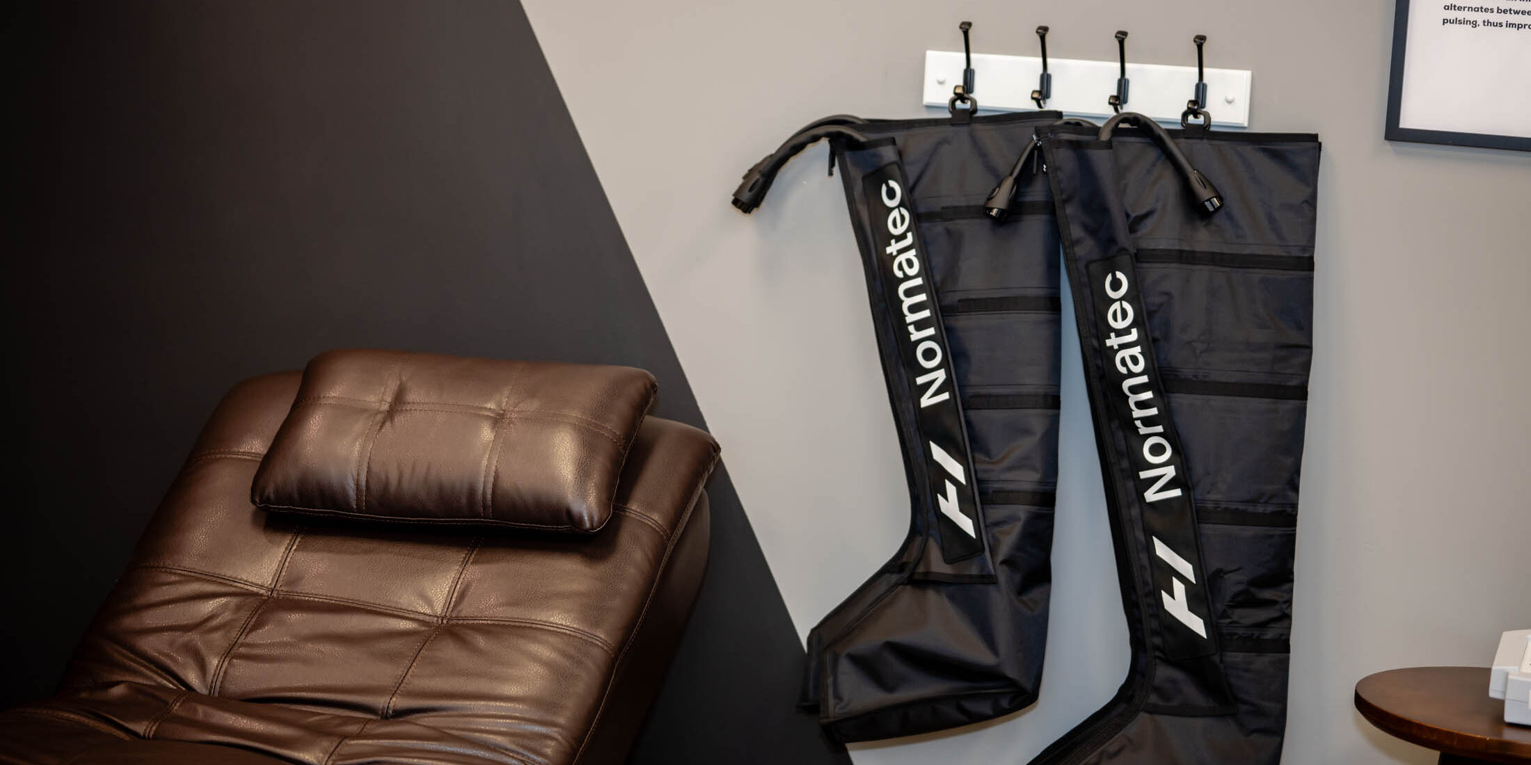 Massage chair and compression boots in room.